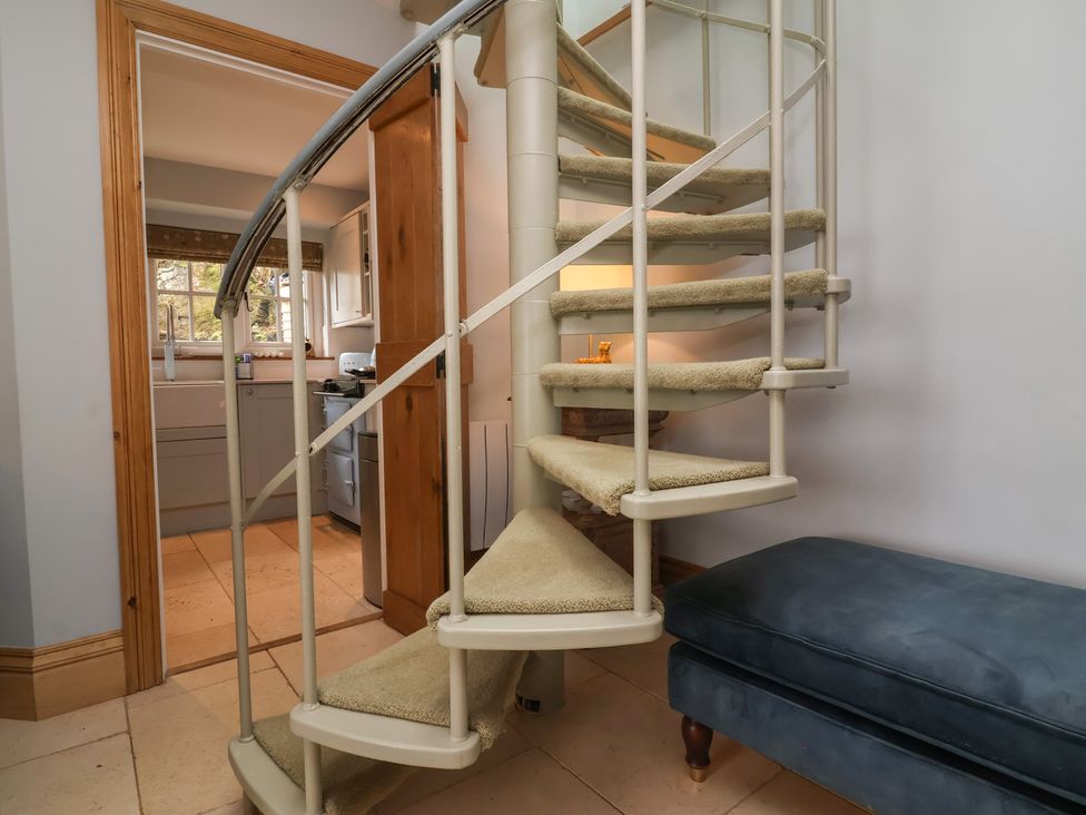 A spiral staircase with a sofa at Rookery Cottage in Lynton