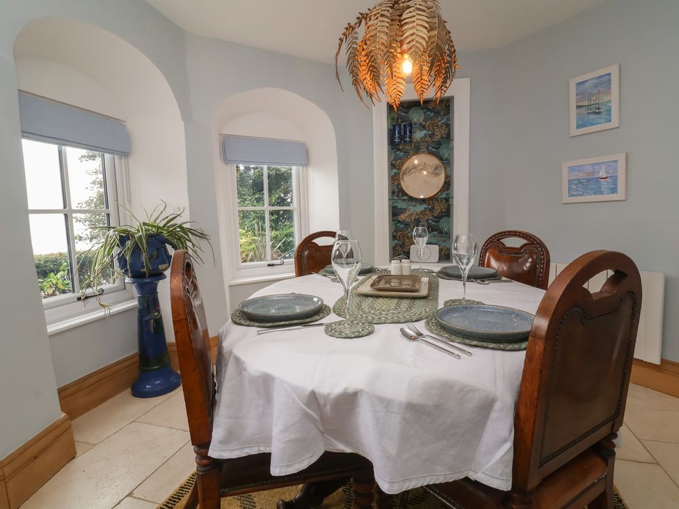 A dining room with a table set for dinner at Rookery Cottage in Lynton