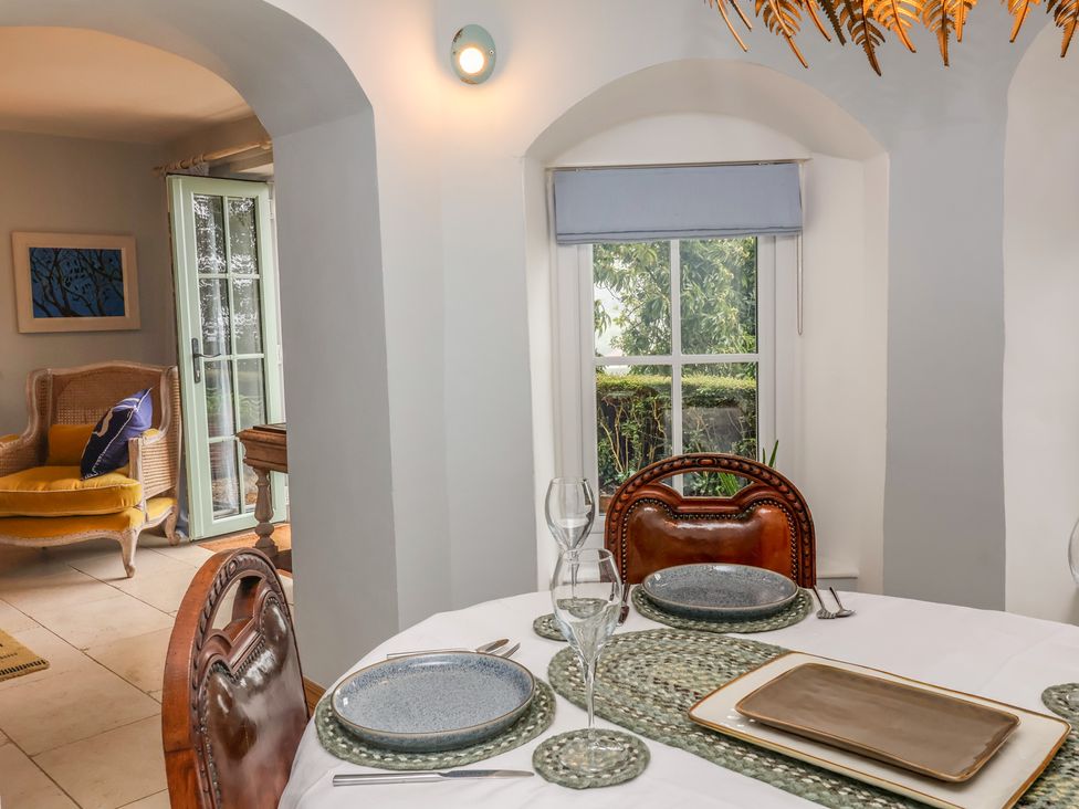 A dining room with a table set for a meal at Rookery Cottage in Lynton