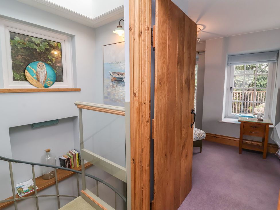 A hallway with a staircase and window at Rookery Cottage in Lynton