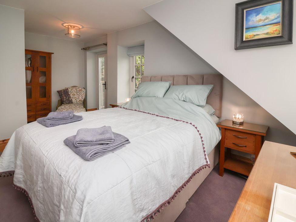 A bedroom with a bed and bedside table at Rookery Cottage in Lynton