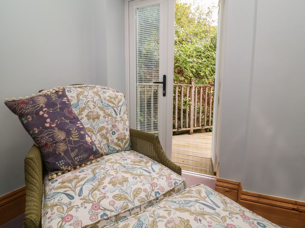 A chair and door leading to a deck at Rookery Cottage in Lynton