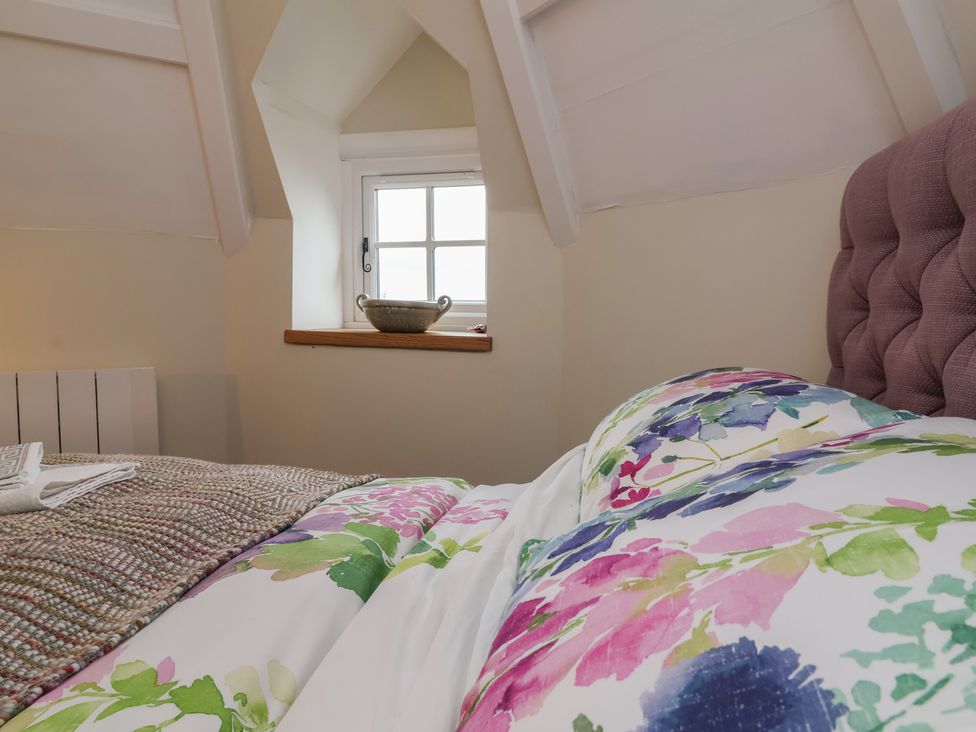 A bedroom with a bed and window at Rookery Cottage in Lynton