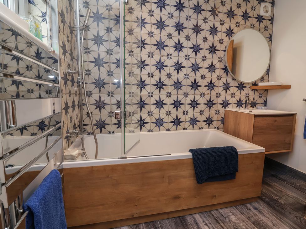A bathroom with a bathtub and shower at Rookery Cottage in Lynton