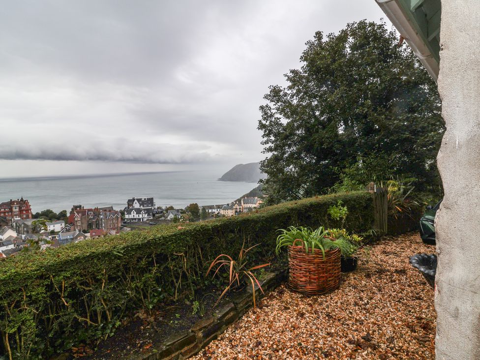 A garden view overlooking the ocean and houses at Rookery Cottage in Lynton