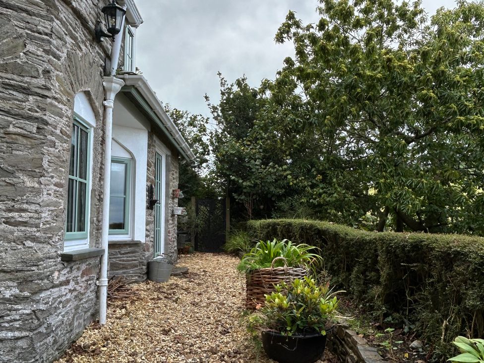 An outdoor pathway with plants and a stone wall at Rookery Cottage in Lynton