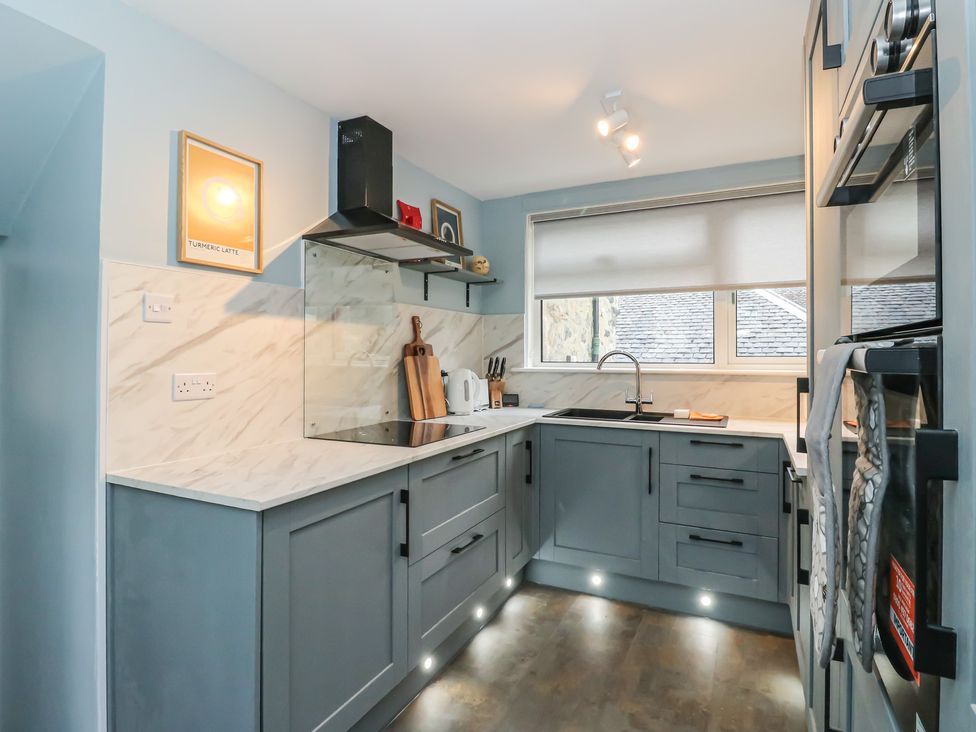 A kitchen with grey cabinets and a sink at Pirnie's Pitlochry