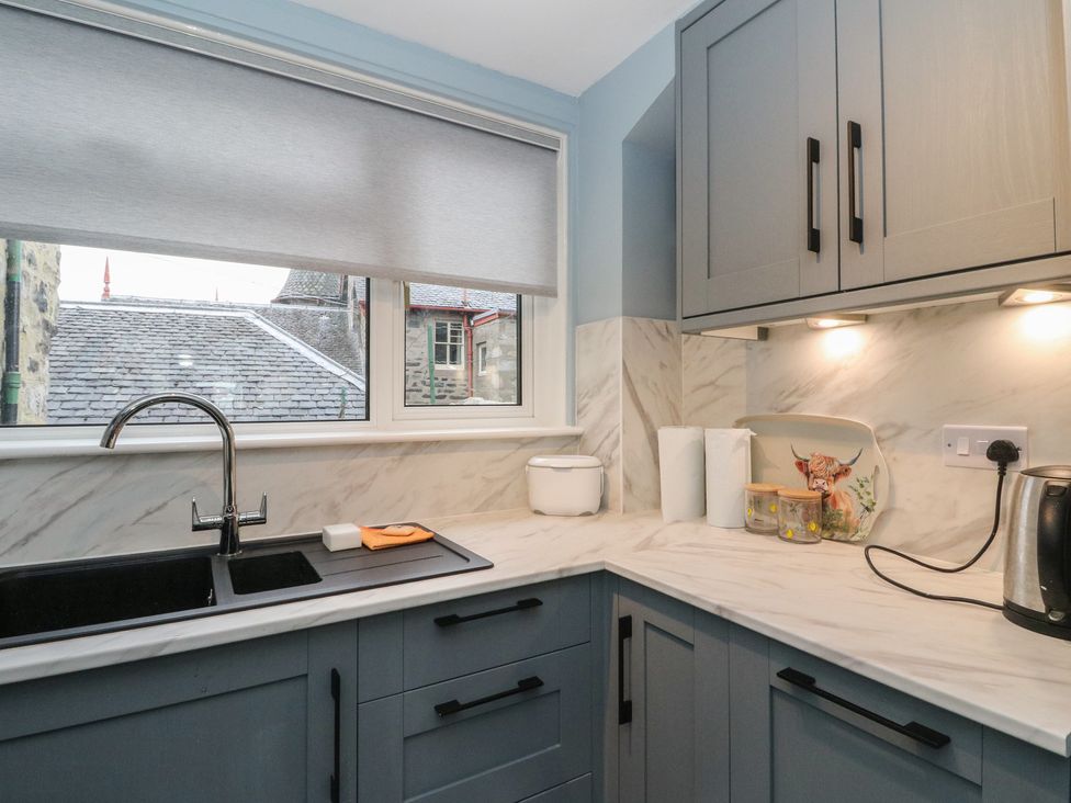 A kitchen with cabinets and sink at Pirnie's in Pitlochry