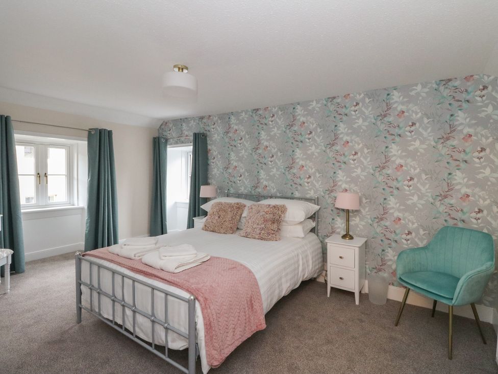 A bedroom with a bed and nightstand at Pirnie's in Pitlochry