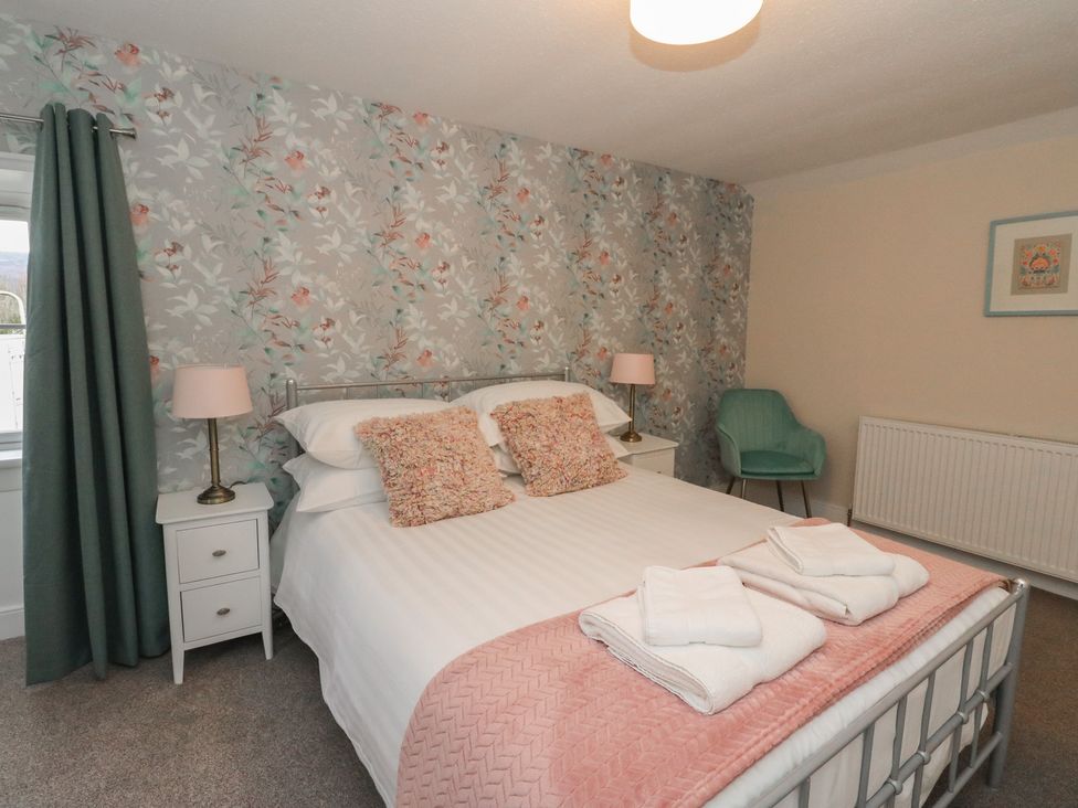 A bedroom with a bed and nightstand at Pirnie's in Pitlochry
