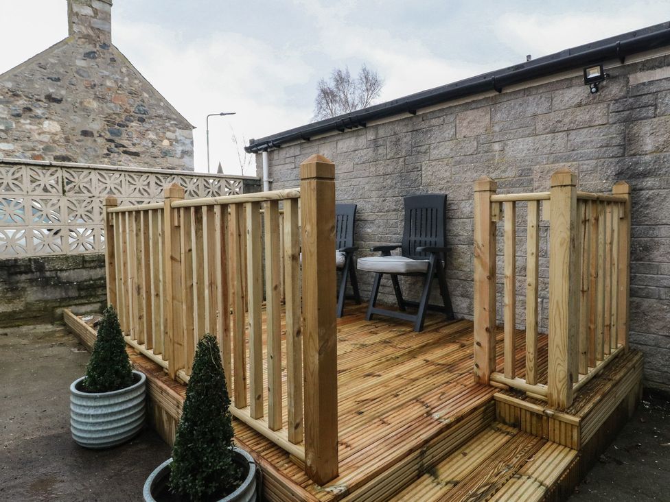 A decking area with chairs and planters at Pirnies in Pitlochry