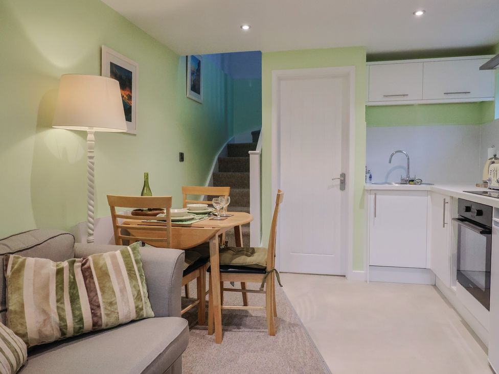 A living room with a dining area and kitchen at Cherry Pip in Charmouth