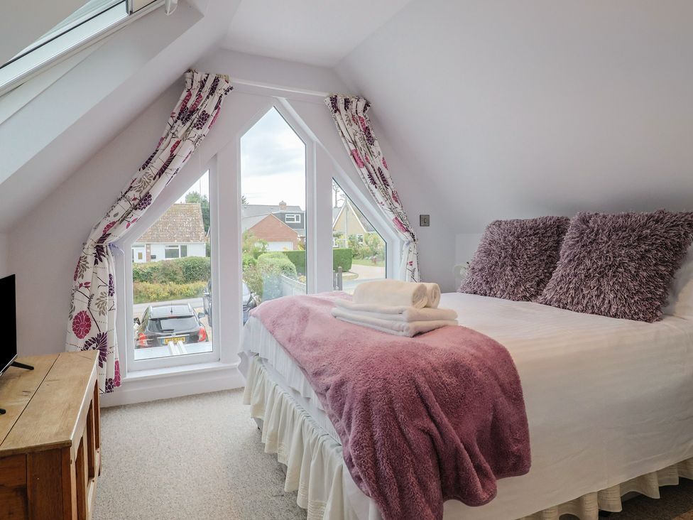 A bedroom with a bed and a television at Cherry Pip in Charmouth
