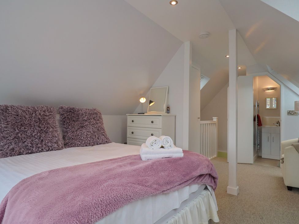 A bedroom with a bed and dresser at Cherry Pip in Charmouth