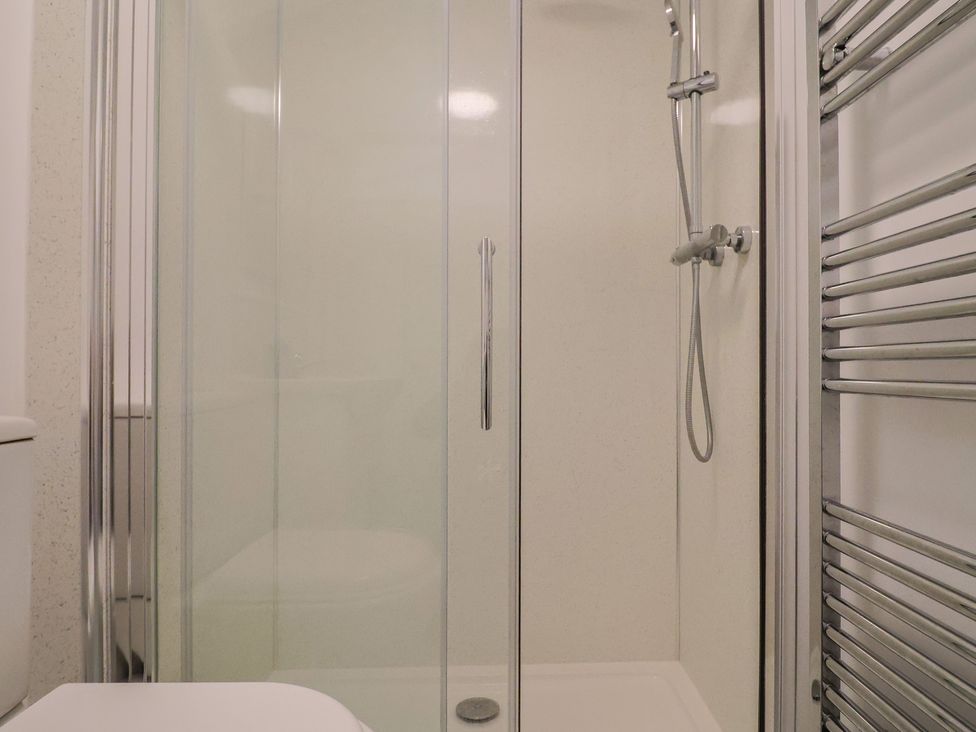 A bathroom with a shower and toilet at Cherry Pip in Charmouth