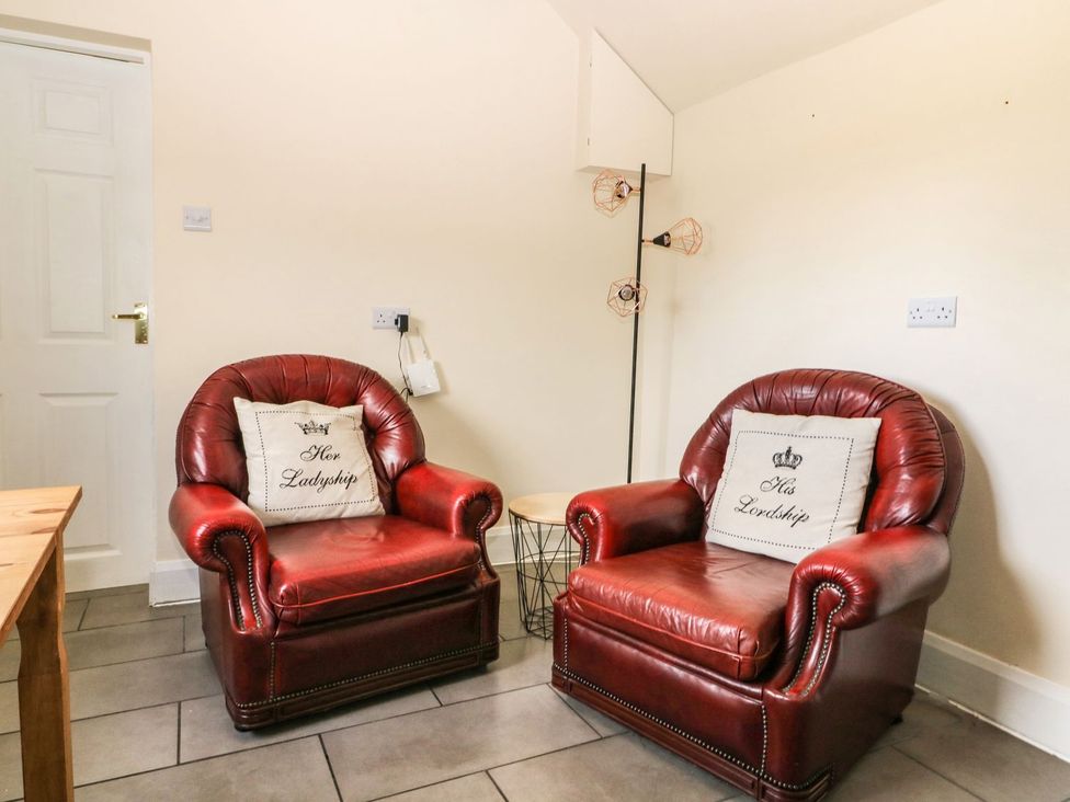 A snug with red armchairs and a side table at 1 Small in Malton