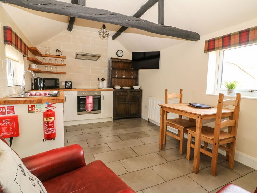 A kitchen with cabinets and a dining table at 1 Small in Malton