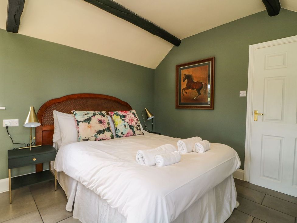 A bedroom with a bed and painting at 1 Small in Malton