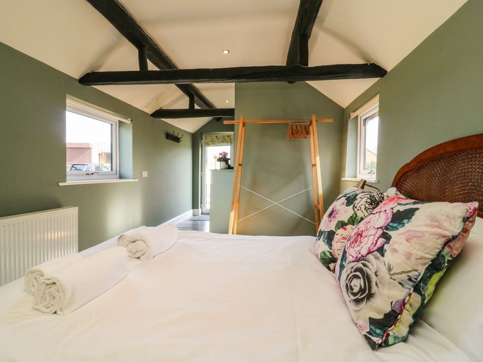 A bedroom with a bed and a clothes rack at 1 Small in Malton
