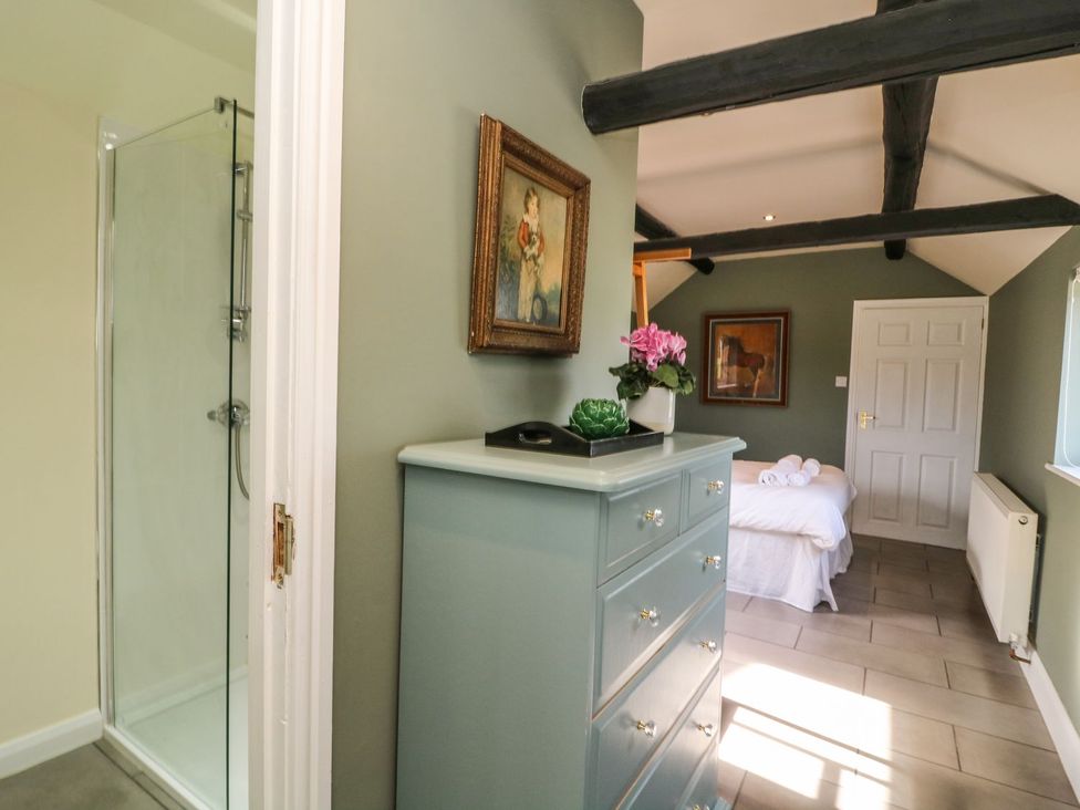 A bedroom with a chest of drawers and a shower at 1 Small in Malton