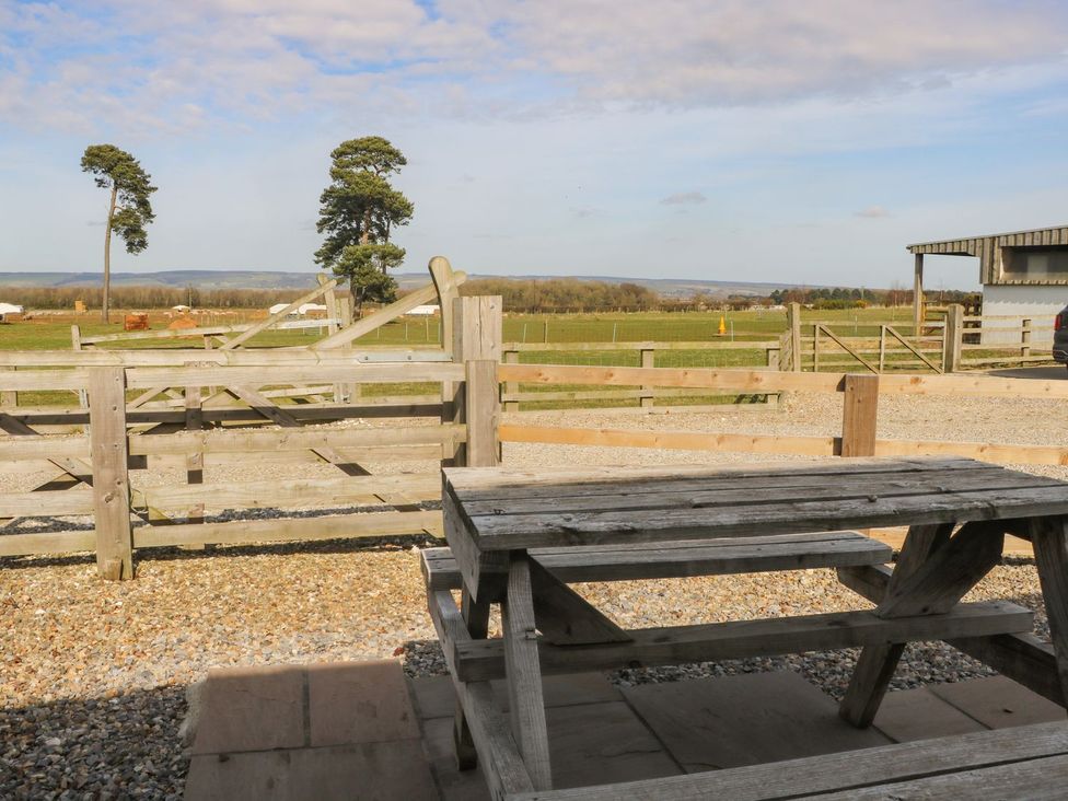 A table with a view of a fenced area and trees at 1 Small in Malton