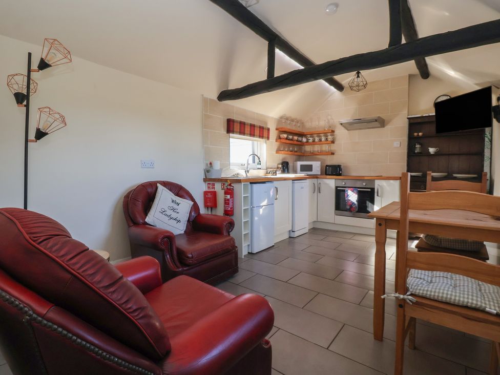 A kitchen with appliances and seating at Cowshed Cottage East Knapton near Rillington