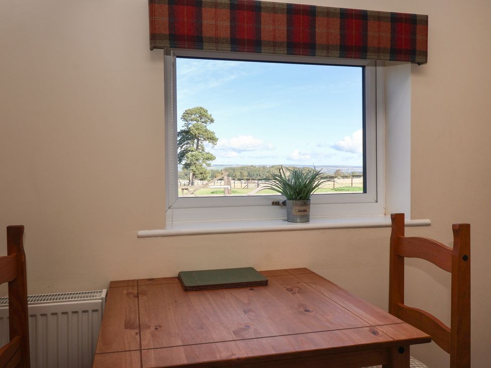 A dining room with a table and chairs at Cowshed Cottage East Knapton near Rillington
