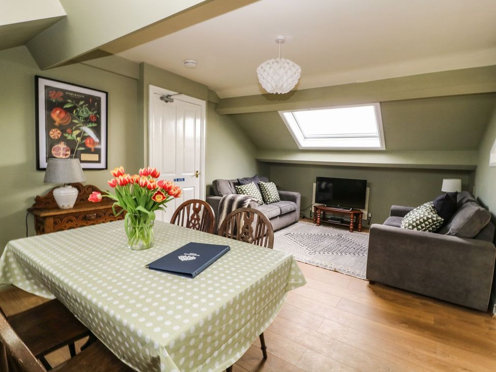 A living room with sofa, TV, and table at 2 Jade side in Malton