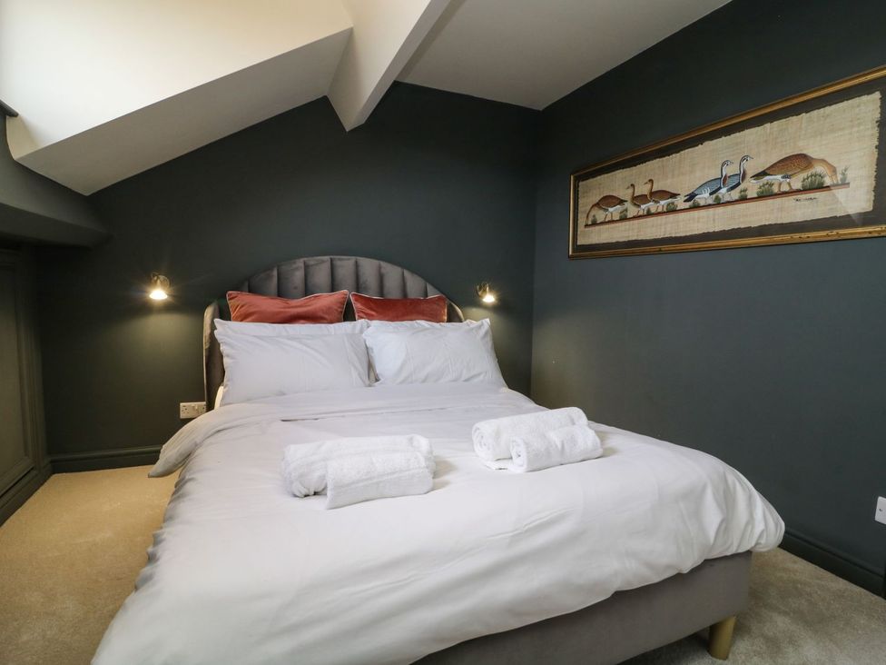 A bedroom with a bed and wall art at 2 Jade side in Malton