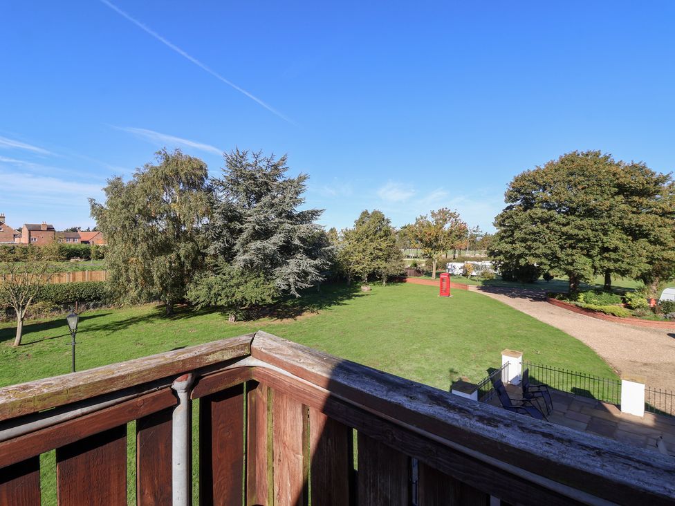 A garden with trees and a red phone box at East Cottage in East Knapton near Rillington