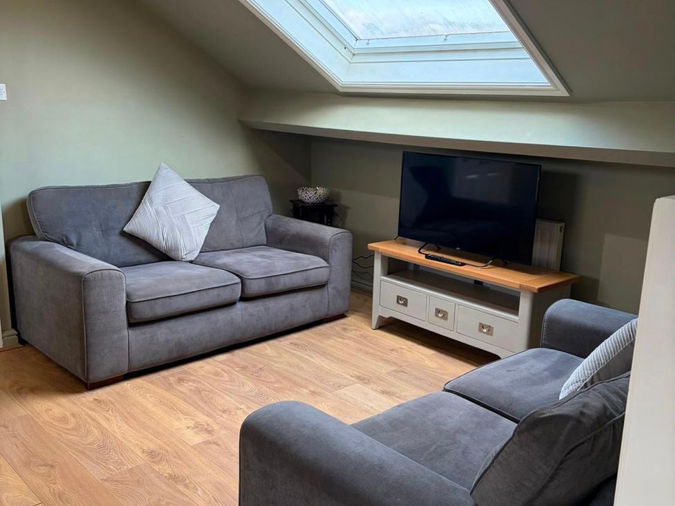 A living room with a sofa and television at West Cottage in East Knapton near Rillington