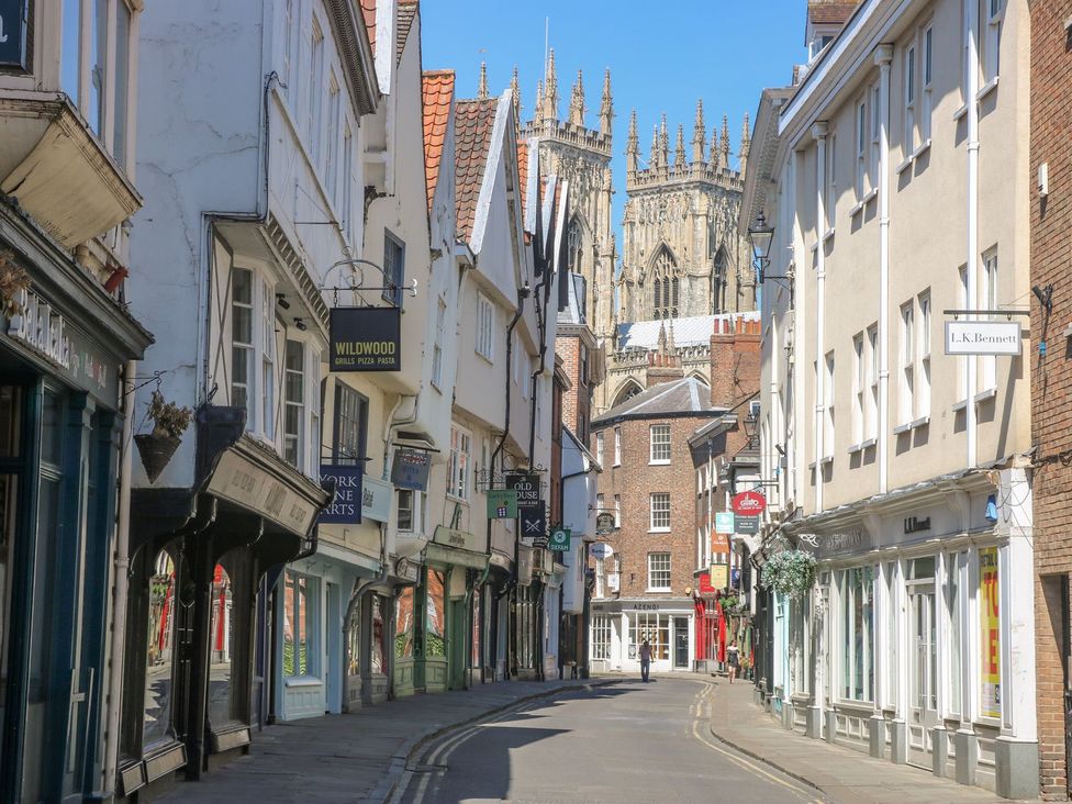A street view with shops and a cathedral in the background at 3 Marinas side, Malton