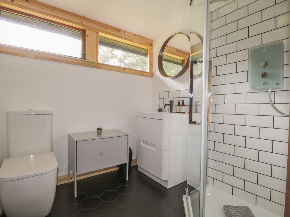 A bathroom with a toilet, sink and shower at Blue Pine Lodge in Dornoch