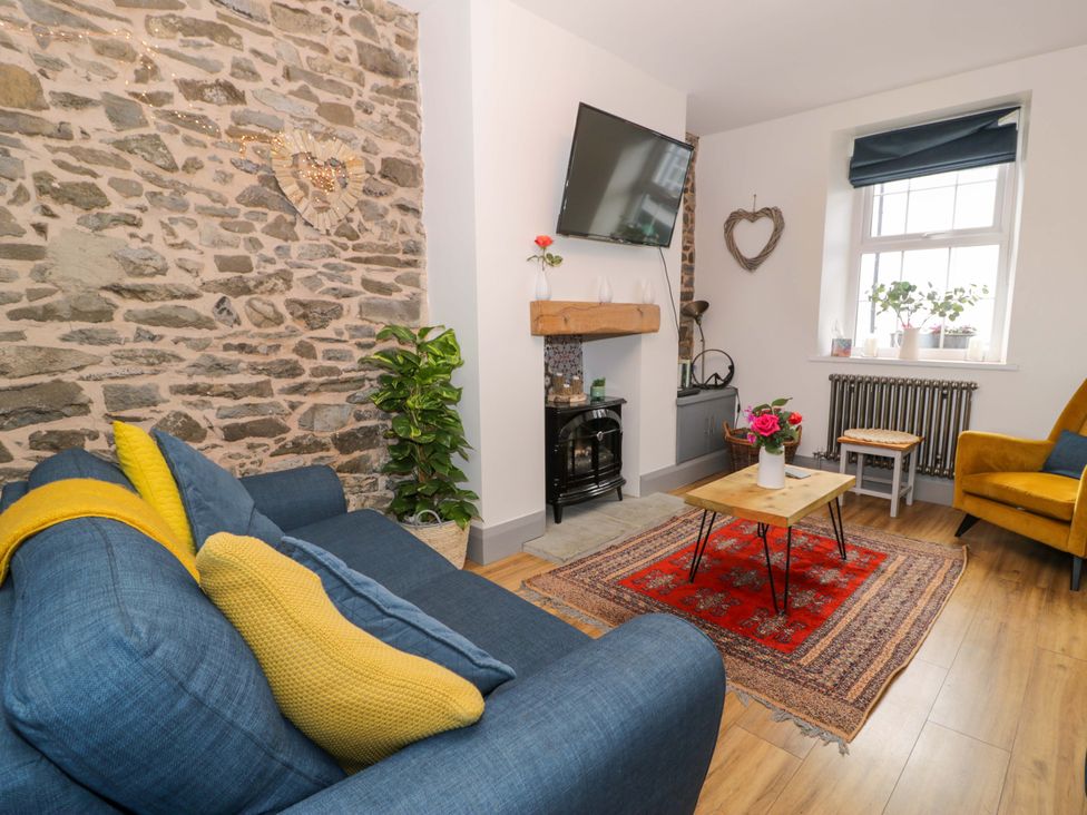 A living room with a sofa and armchair at 8 Watkin Street Conwy