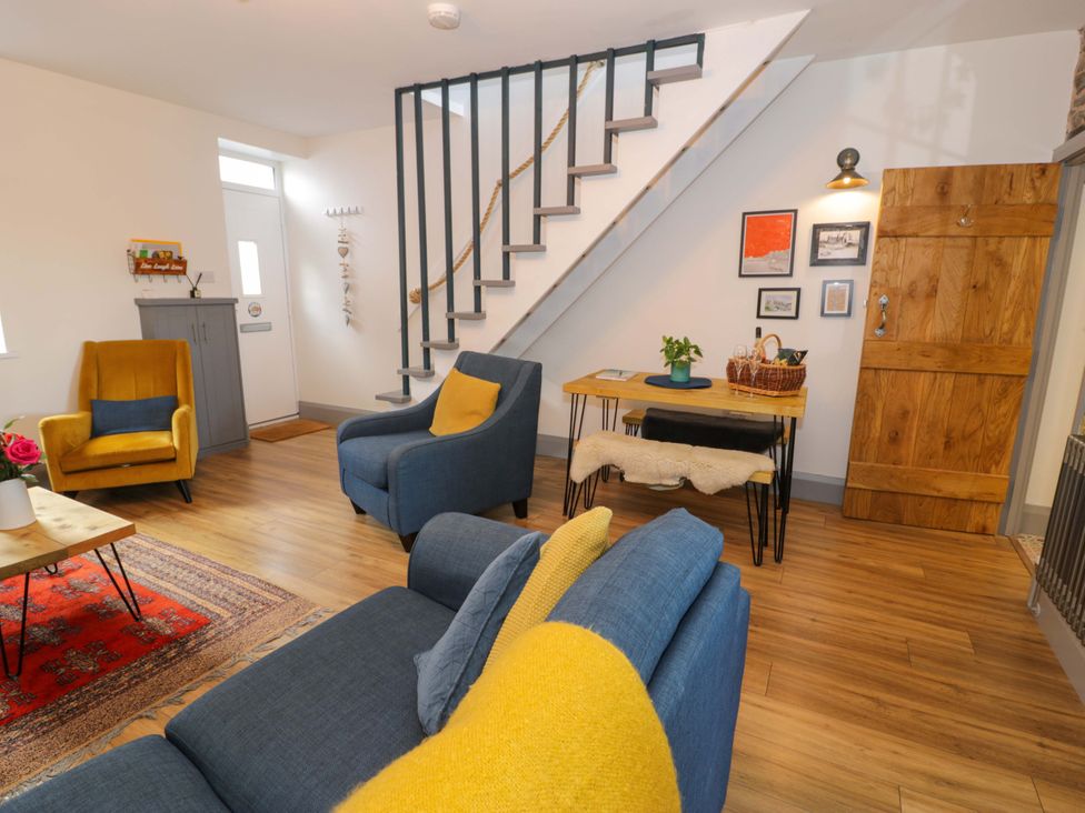 A living room with a sofa and armchair at 8 Watkin Street in Conwy