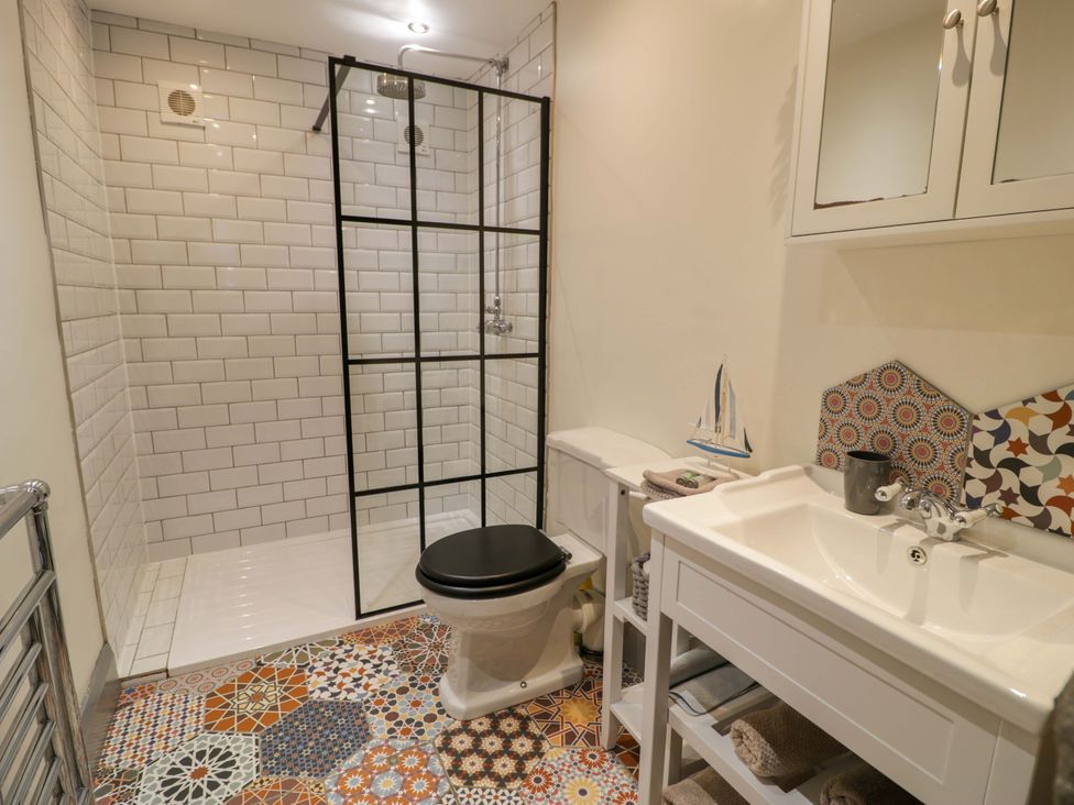A bathroom with a shower, toilet and wash basin at 8 Watkin Street, Conwy