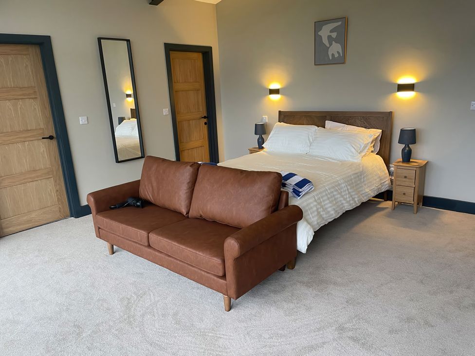 A bedroom with a bed and a sofa at Spring Meadow in Croxdale