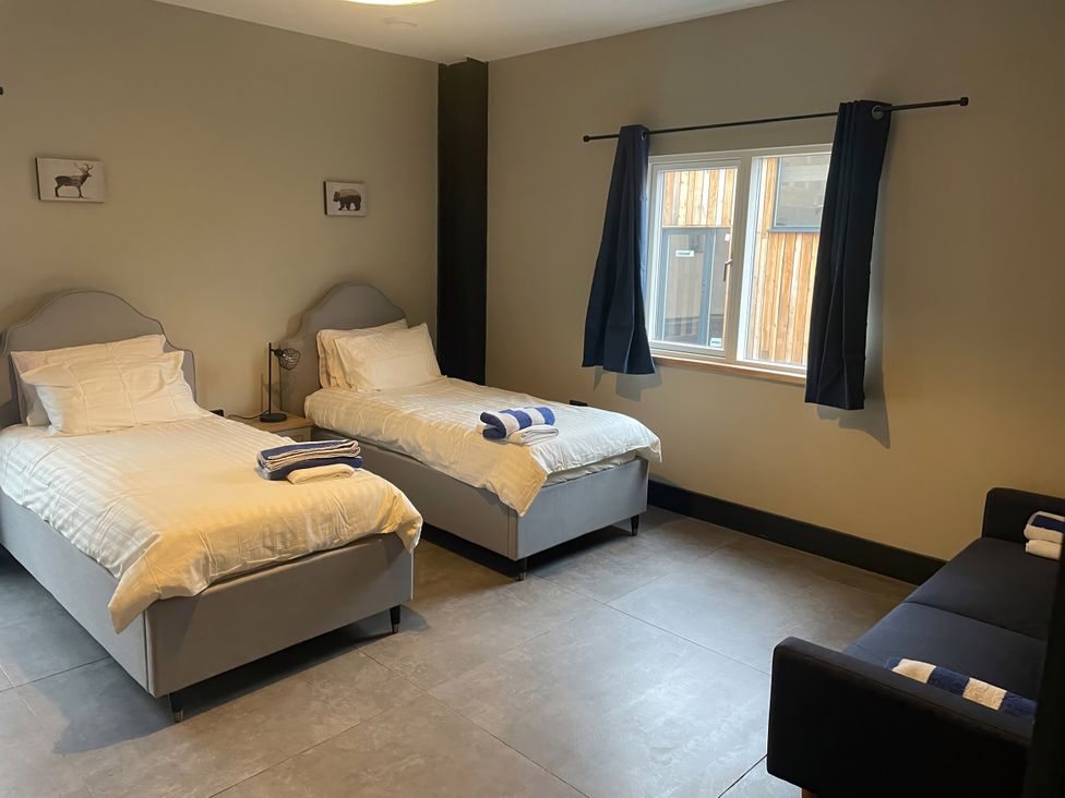 A bedroom with two beds and a sofa at Spring Meadow in Croxdale