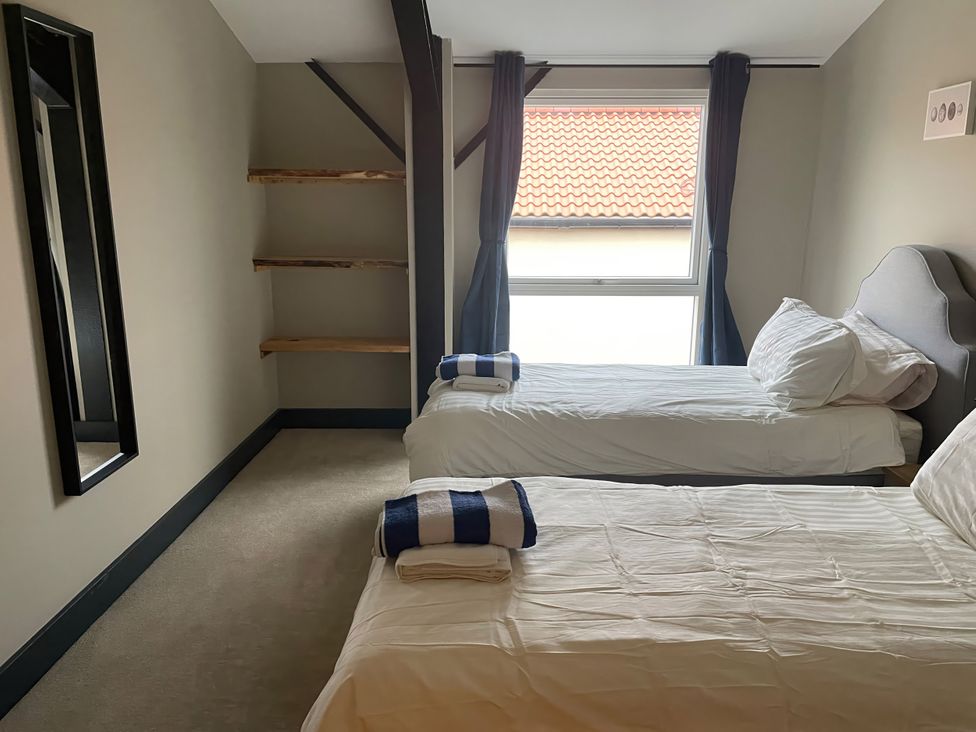 A bedroom with two beds and a mirror at Spring Meadow in Croxdale