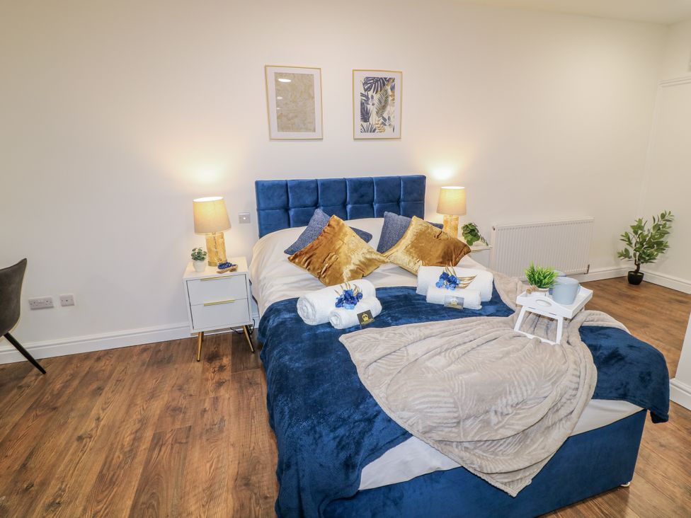 A bedroom with a bed and side tables at 2, Peterborough