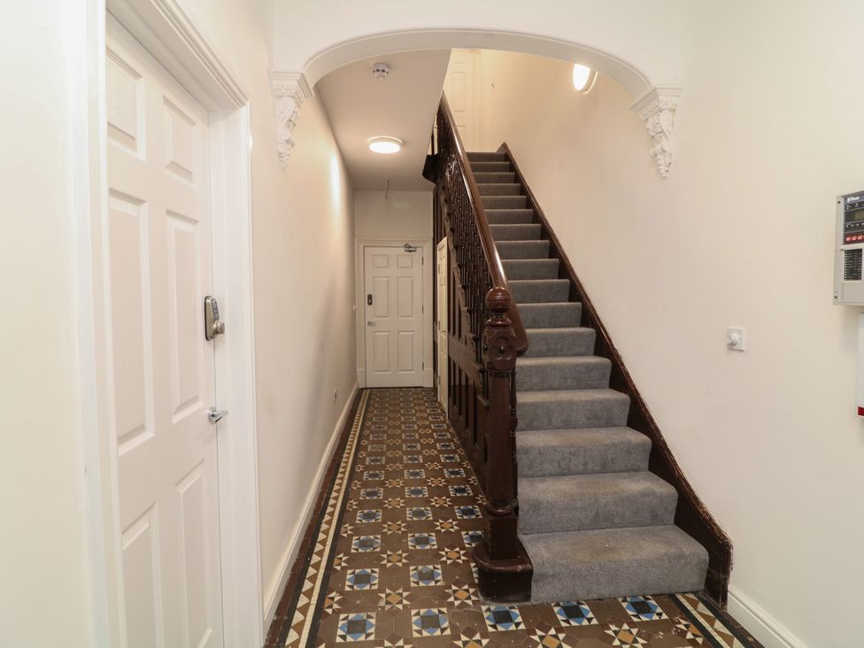 A hallway with a staircase and doors at 2, Peterborough