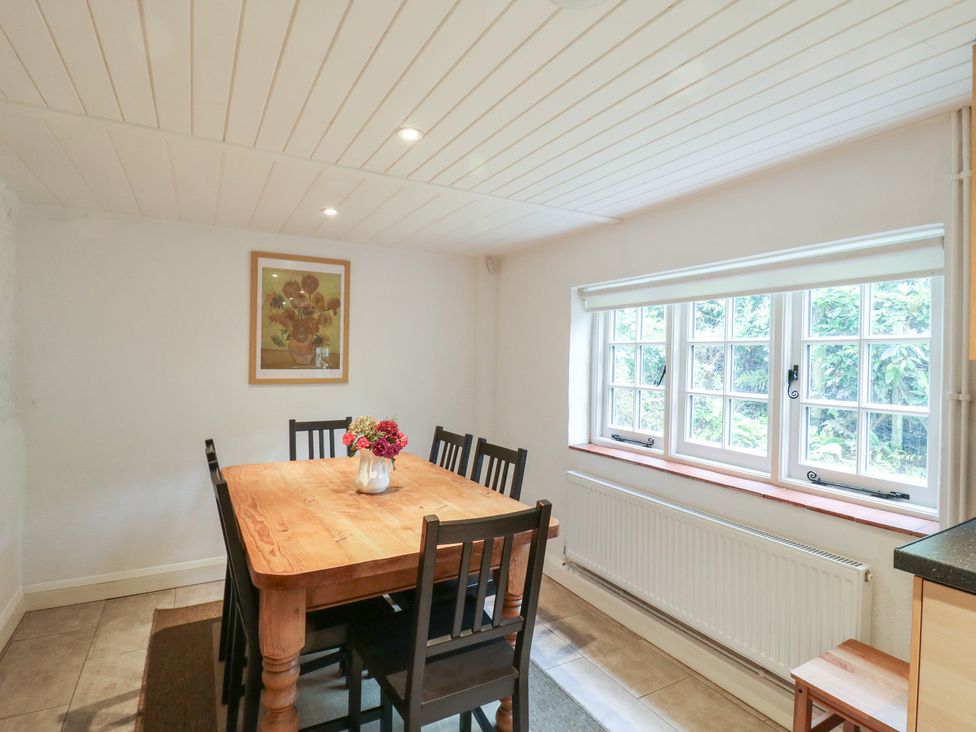 A dining room with a wooden table and chairs at Cherry Cottage