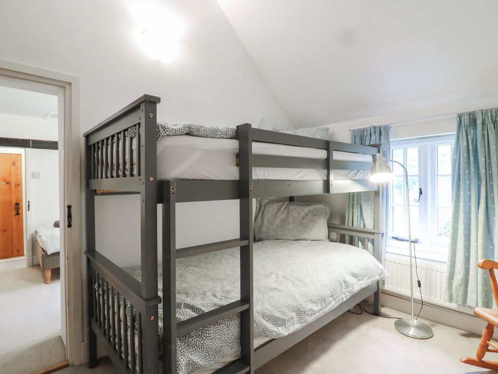 A bedroom with a bunk bed and a window at Cherry Cottage