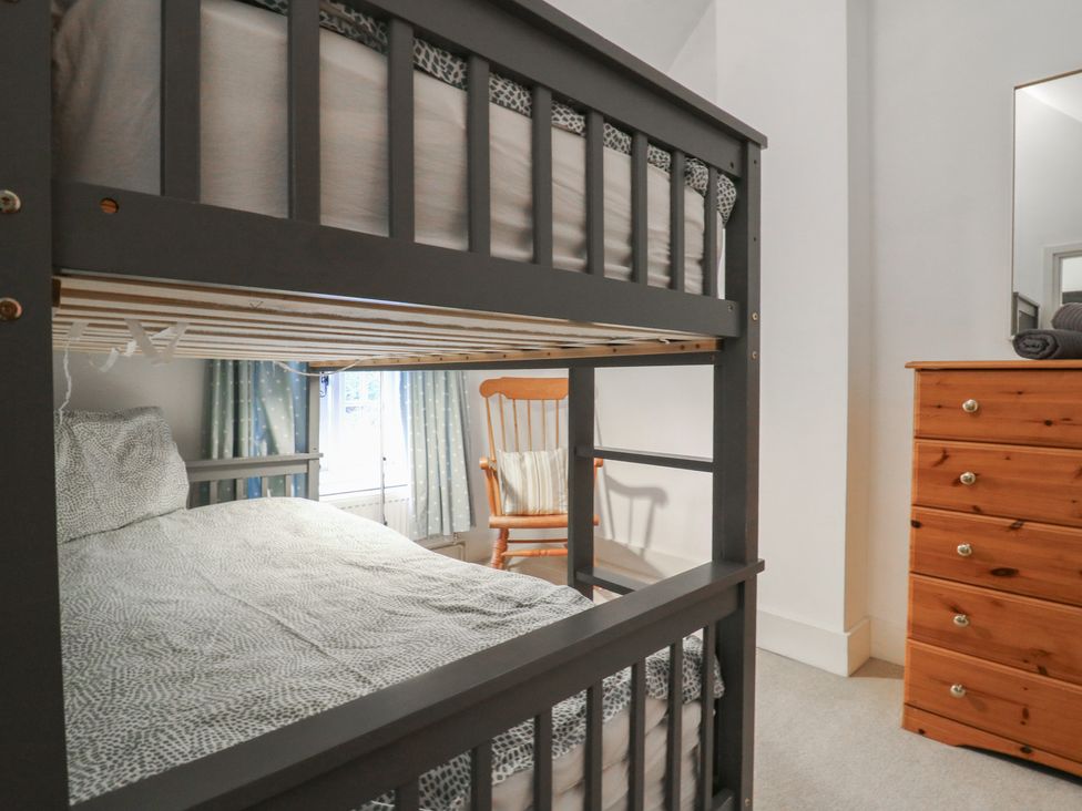 A bedroom with a bunk bed and double bed at Cherry Cottage