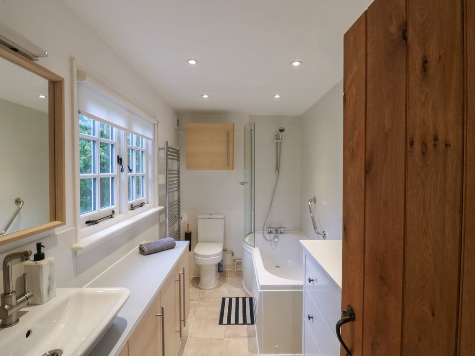 A bathroom with a sink, toilet, bathtub, and shower at Cherry Cottage