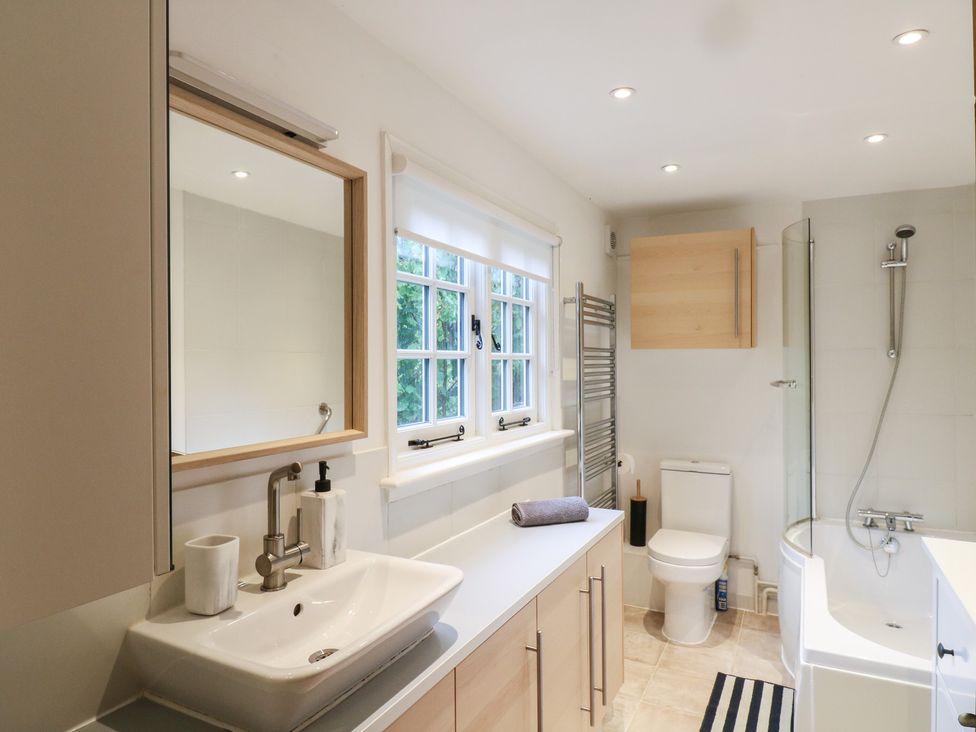 A bathroom featuring a sink, shower, toilet, and mirror at Cherry Cottage