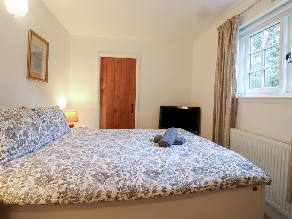 A bedroom with a bed and television at Cherry Cottage