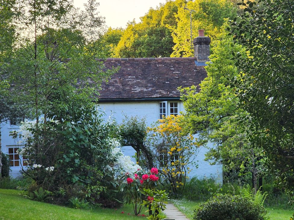 A house with flowers and trees in front at Cherry Cottage in Crowborough