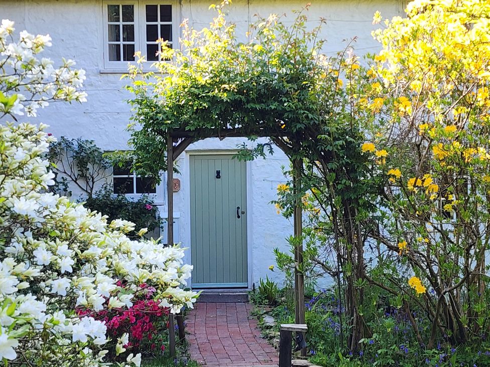 An entrance pathway with a door framed by flowers at Cherry Cottage in Crowborough