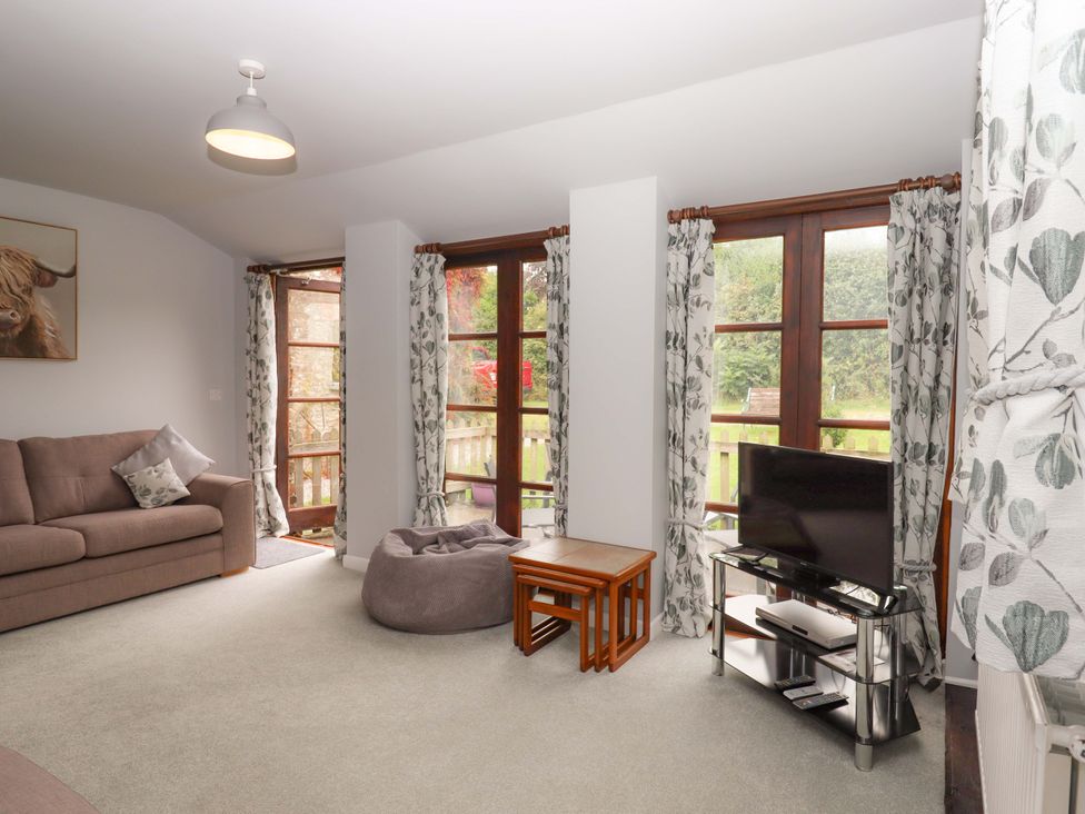 A living room with a sofa and television at The Milking Shippon at Thorne in Langtree near Great Torrington